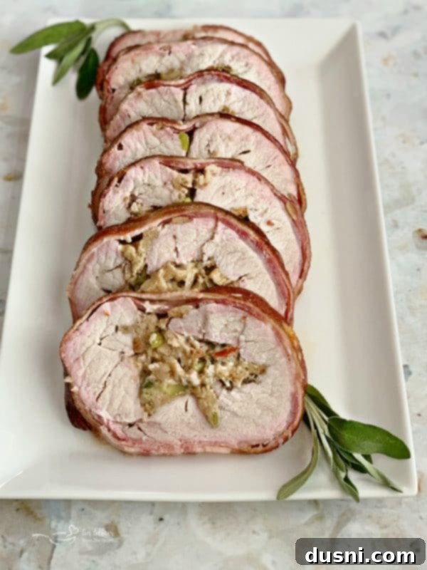 Pastırmalı Lahana Turşusu Dolgulu Domuz Kontrafile 2 Perfectly smoked bacon-wrapped pork loin with sauerkraut stuffing on a white platter, ready to be sliced.