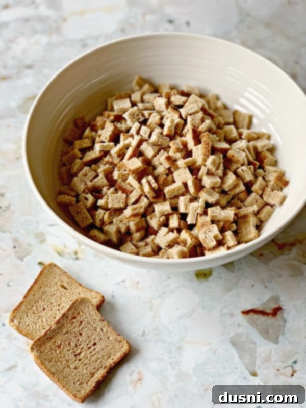 Pastırmalı Lahana Turşusu Dolgulu Domuz Kontrafile 5 Homemade rye bread crumbs for the sauerkraut stuffing, showing cubed rye bread on a baking sheet.