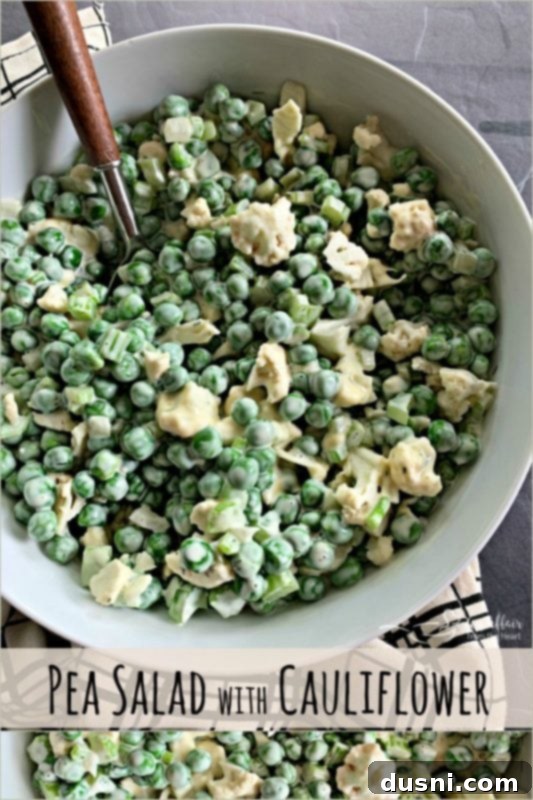 A close-up of Pea Salad with Cauliflower in a white bowl on a wooden surface.