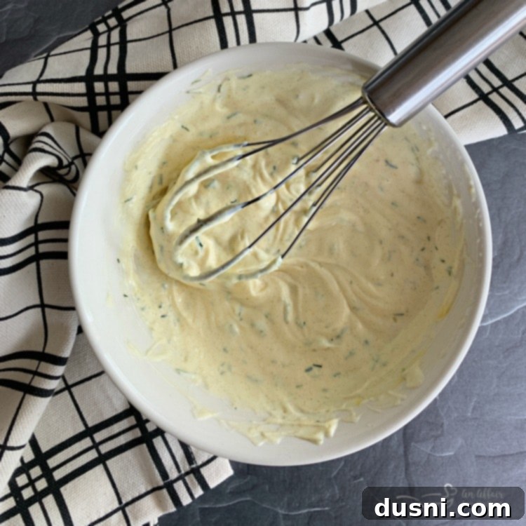 Ingredients for the creamy dill dressing for pea salad being mixed in a bowl.