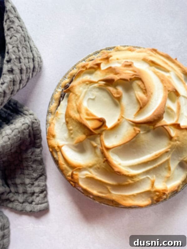 A beautifully baked chocolate meringue pie with a golden brown meringue topping.