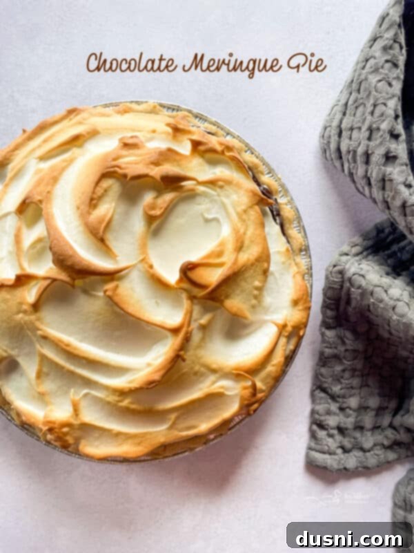 A close-up of a slice of chocolate meringue pie on a plate, ready to be served.
