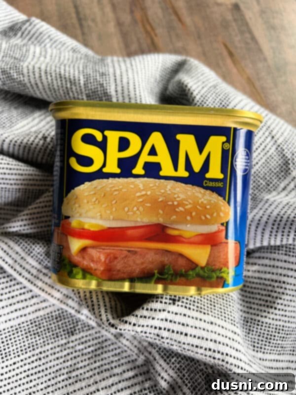 Overhead view of a vibrant Spam pasta salad with fresh vegetables and macaroni in a large mixing bowl.