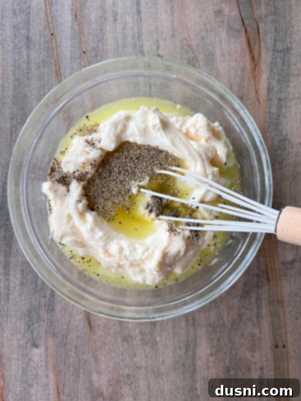 Cooked elbow macaroni being rinsed in a colander under cold water.