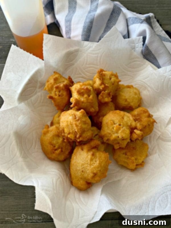 Delicious golden-brown corn fritters piled high, ready to be served.