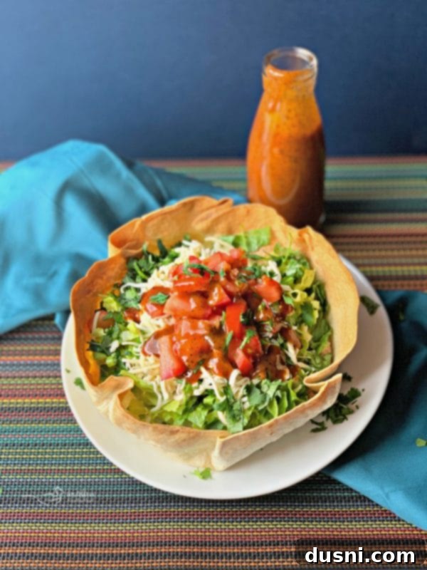 Delicious Taco Salad served in a homemade taco bowl, generously drizzled with Dorothy Lynch Taco Sauce