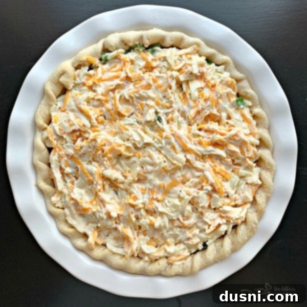 Adding cheese mixture to tomato pie