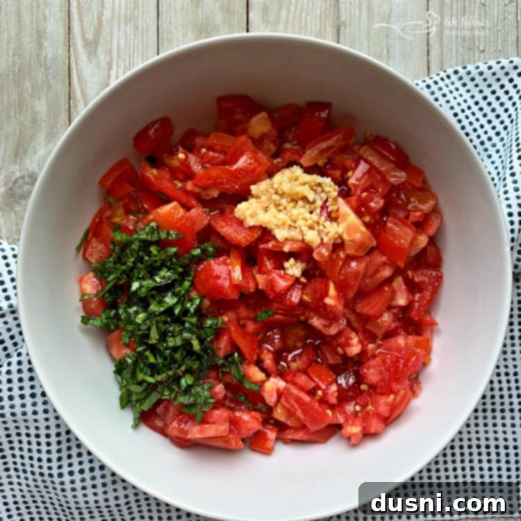 Ingredients for Tomato Bruschetta being prepped in a bowl