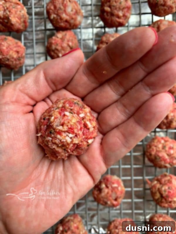 Meatball mixture being rolled into small balls