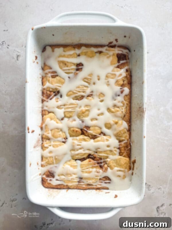 Glazed Snickerdoodle Bars 13 Drizzling vanilla glaze over cooled snickerdoodle bars in a baking pan.