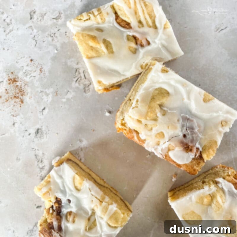 Glazed Snickerdoodle Bars 6 Finished Iced Snickerdoodle Bars on a serving platter, showing the cinnamon swirls and vanilla glaze.