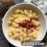 Overhead of Beer Cheese Pasta Sauce with bacon in a white bowl