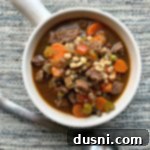 Hearty Instant Pot Beef and Vegetable Soup 15 overhead of Instant Pot Vegetable Beef Soup in a white mug