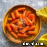 Sunshine Glazed Carrots 14 Overhead view of a wooden plate with perfectly orange glazed baby carrots