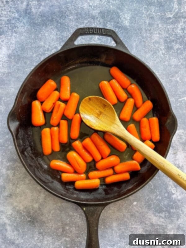 Sunshine Glazed Carrots 6 Orange juice, brown sugar, and butter being poured over cooked carrots in a pan