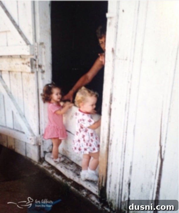 Kids looking at kittens in a barn with grandma
