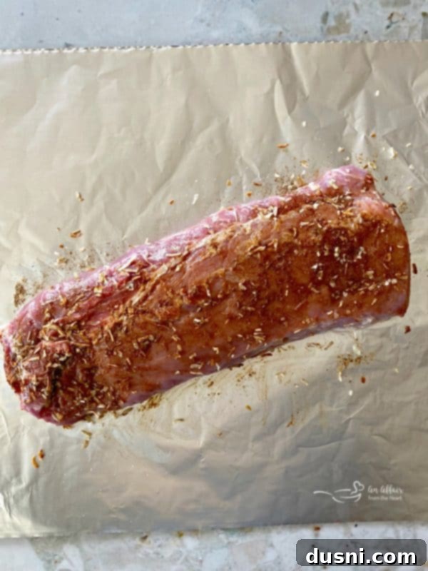 Pork loin roast being prepped with onion soup mix on foil