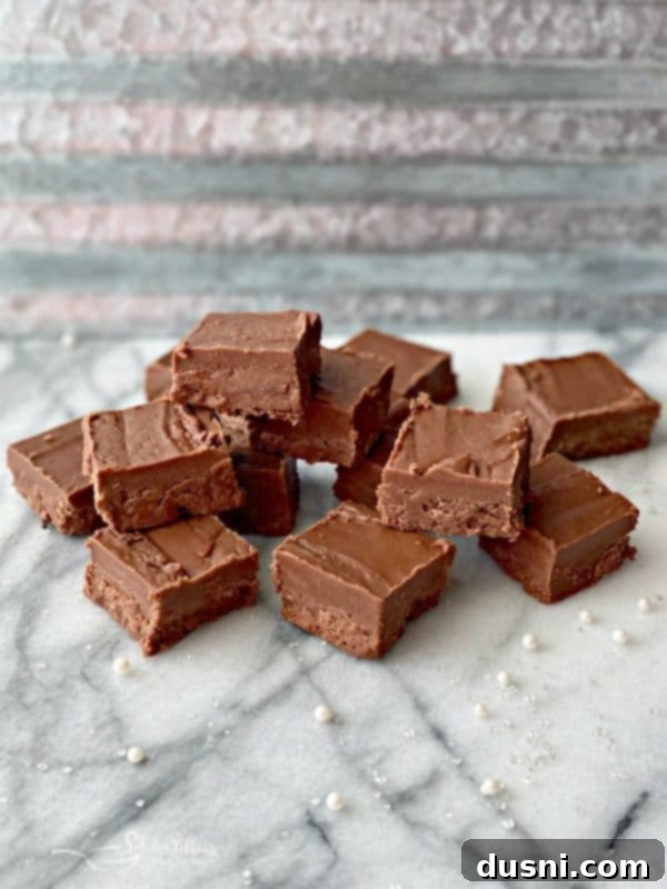 Rich, smooth, and creamy Never Fail Fudge squares on a plate, ready to be enjoyed.