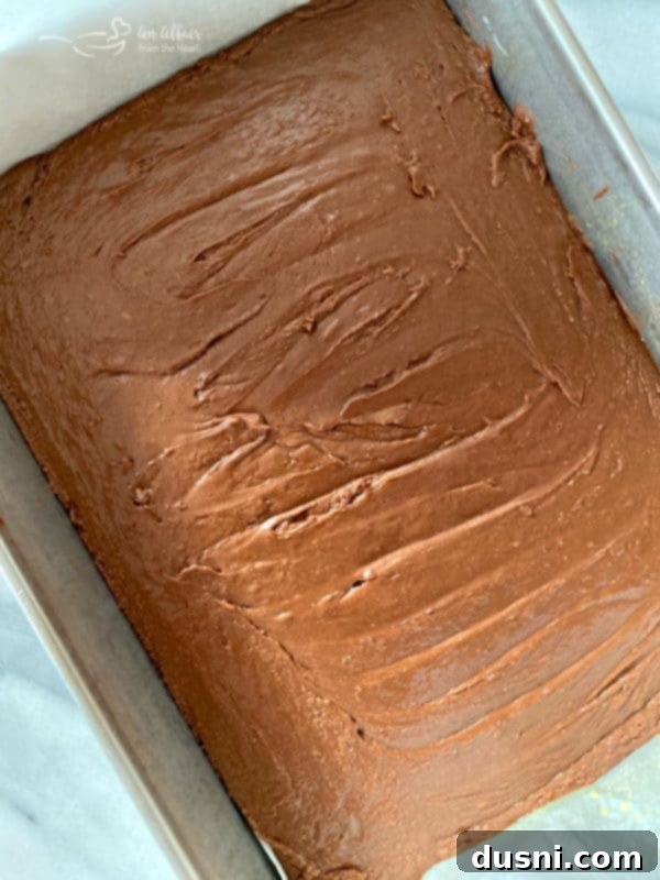 Freshly poured Never Fail Fudge spread evenly in a 9x13 inch pan, ready for chilling.