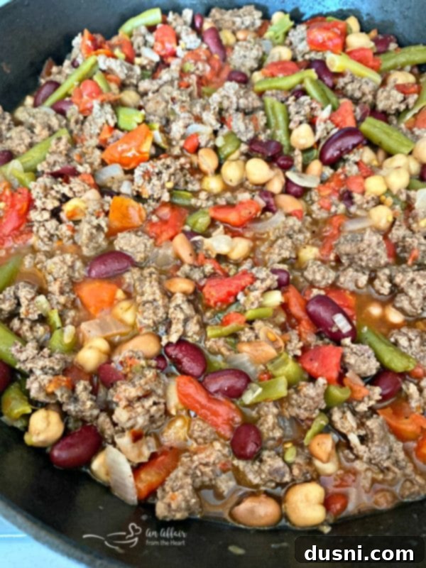 Close-up of the simmering five bean beef and noodle casserole mixture