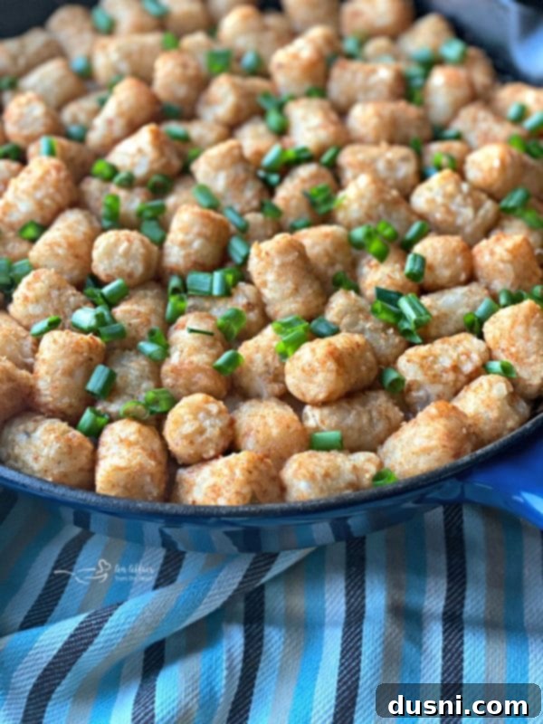 Beef & Kraut Tater Tot Casserole baking in a cast iron skillet.