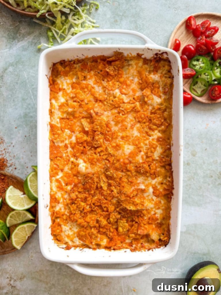 Casserole assembled with layers of beans, chicken, cheese, and Doritos.