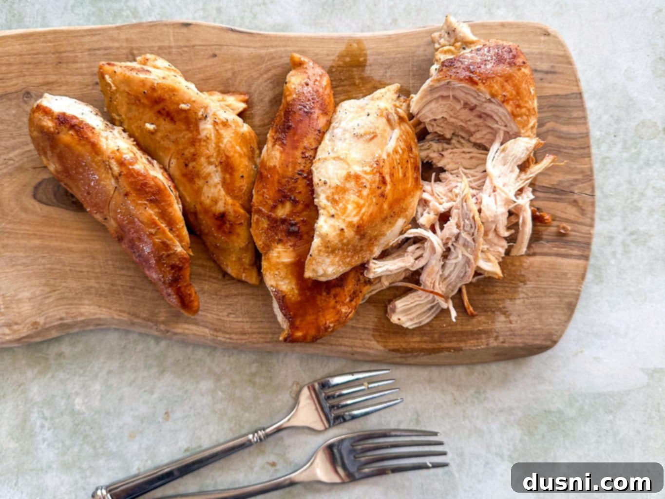 Chicken breasts cooking in a pan.