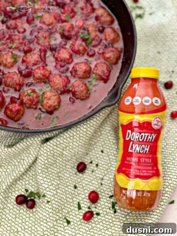 Dorothy Cranberry Meatballs 3 A bottle of Dorothy Lynch Homestyle Dressing sits beside a bowl of cranberry meatballs, highlighting the key ingredient.
