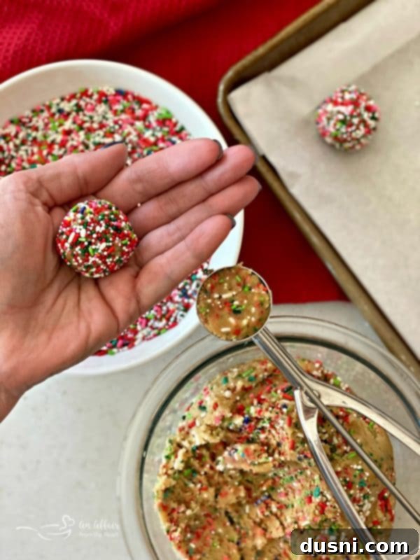 Festive Funfetti Sugar Cookies 13 Uniform balls of Funfetti Sugar Cookie dough covered in colorful sprinkles, ready for baking