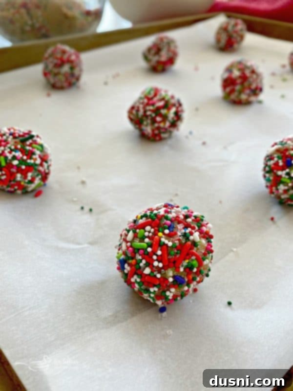 Festive Funfetti Sugar Cookies 14 Closeup of Funfetti Sugar Cookie dough balls heavily coated in a variety of colorful sprinkles