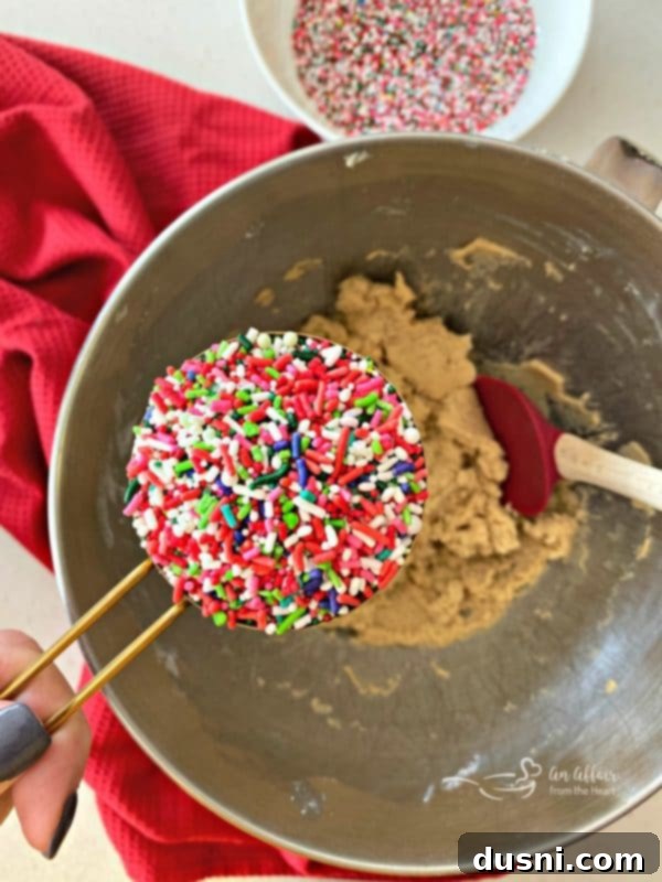 Festive Funfetti Sugar Cookies 9 Raw Funfetti Sugar Cookie dough in a mixing bowl, with colorful sprinkles folded in