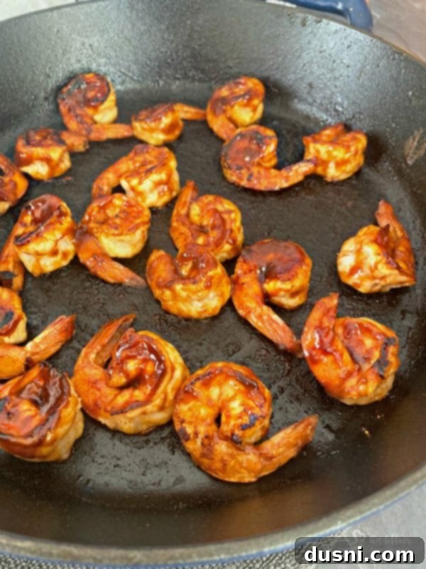 Spicy Caribbean Shrimp sizzling in a cast iron skillet