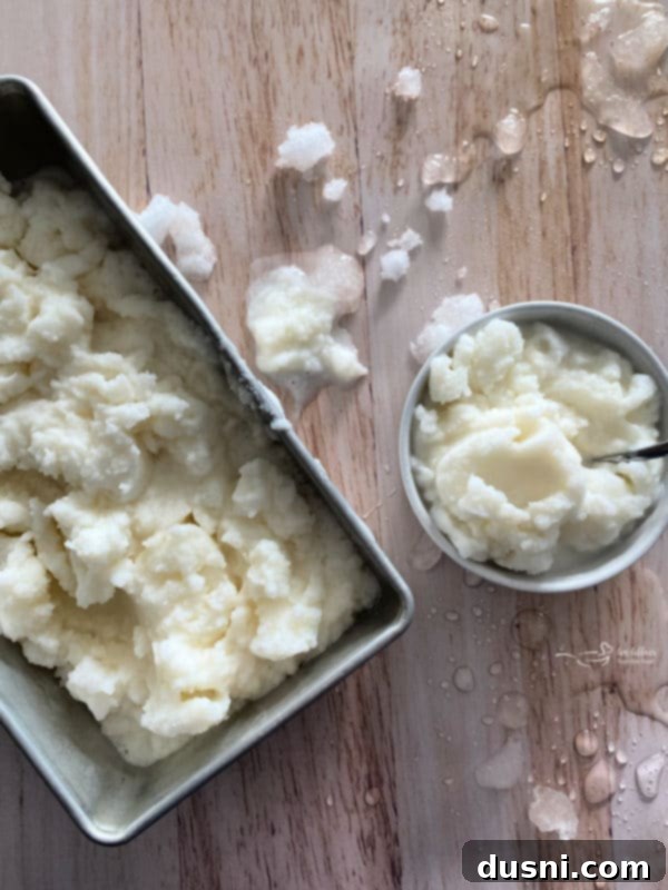 A large spoonful of snow ice cream being lifted from a bowl.