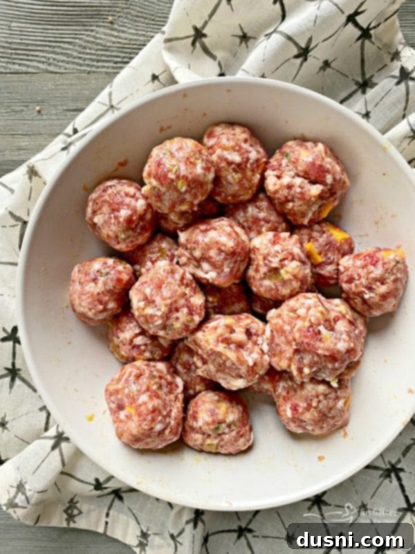 Golden Pretzel Sausage Bites with Zesty Cheese Sauce 10 Portioning meatballs for Sausage Pretzel Bombs using a cookie scoop