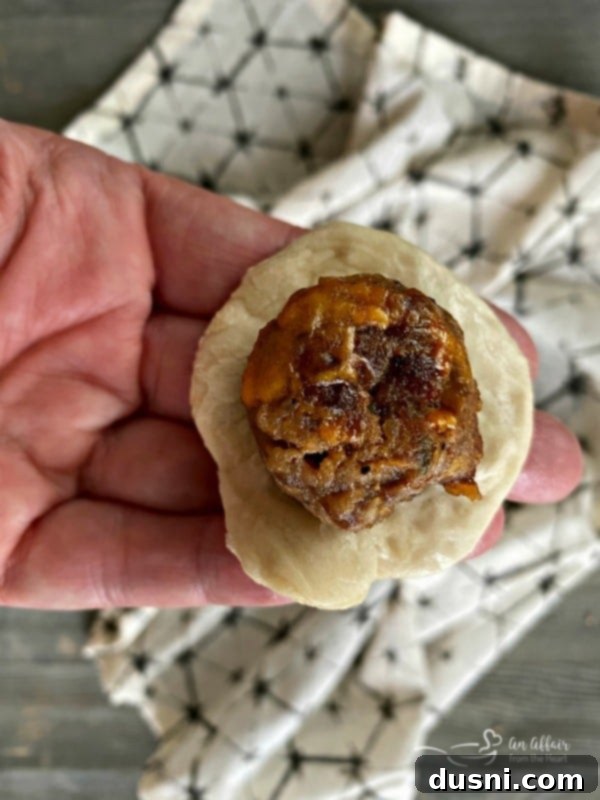 Golden Pretzel Sausage Bites with Zesty Cheese Sauce 12 Stuffing a sausage meatball into bread dough for pretzel bombs