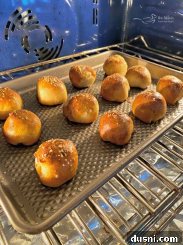 Golden Pretzel Sausage Bites with Zesty Cheese Sauce 14 Sausage Pretzel Bombs baking to a golden brown in the oven