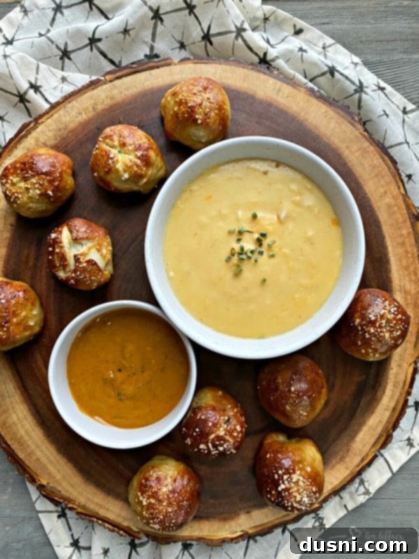 Golden Pretzel Sausage Bites with Zesty Cheese Sauce 6 Close-up of an appetizer platter featuring Sausage Pretzel Bombs with Mustard Cheese Sauce