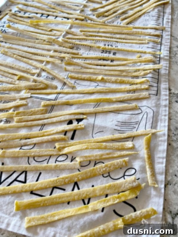 Homemade egg noodles drying on a tea towel