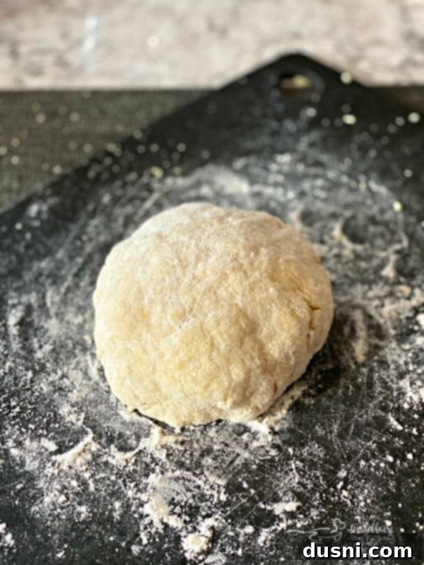 Homemade egg noodle dough being kneaded