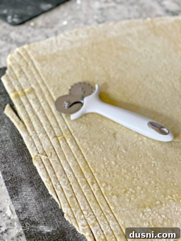 Cutting homemade egg noodles with a pastry cutter