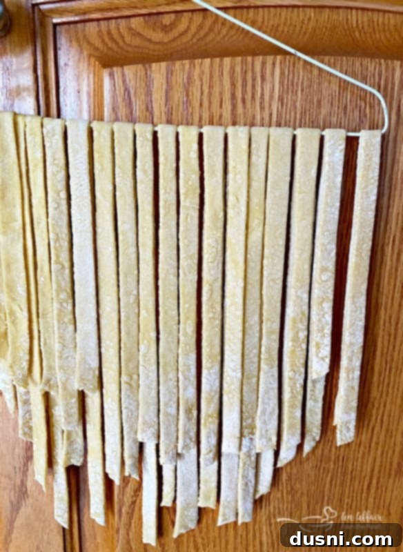 Homemade egg noodles drying on a hanger