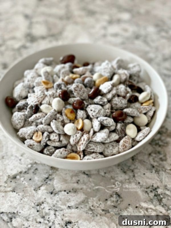 Tuxedo Muddy Buddies snack mix in a bowl with powdered sugar