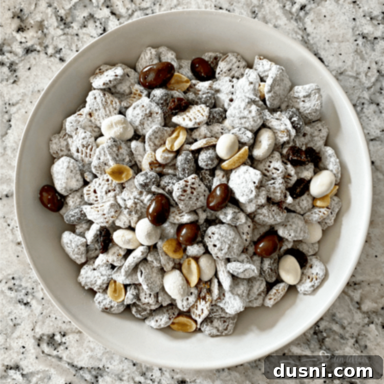 Close-up of Tuxedo Muddy Buddies in a bowl, showing the powdered sugar coating