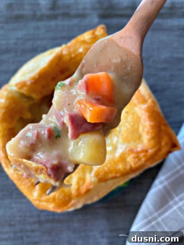 Delicious individual Reuben Pot Pies with a bite taken out, showcasing the rich filling and flaky pastry.