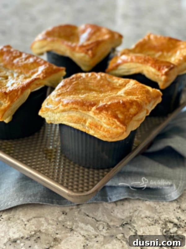 Close-up of baked Reuben Pot Pies, highlighting the golden, flaky puff pastry.