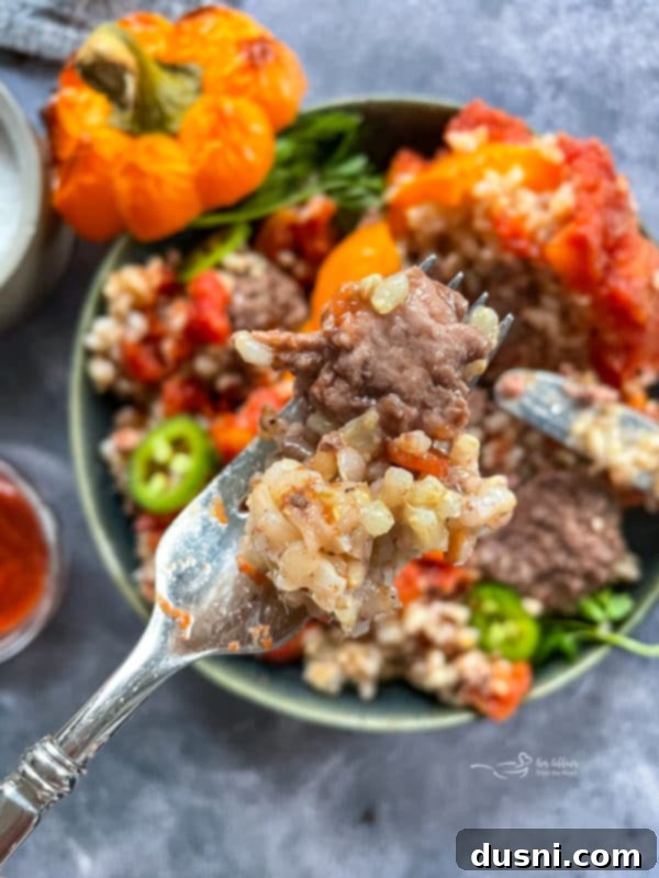 Close-up of a stuffed pepper piece on a fork, showing the rich filling.