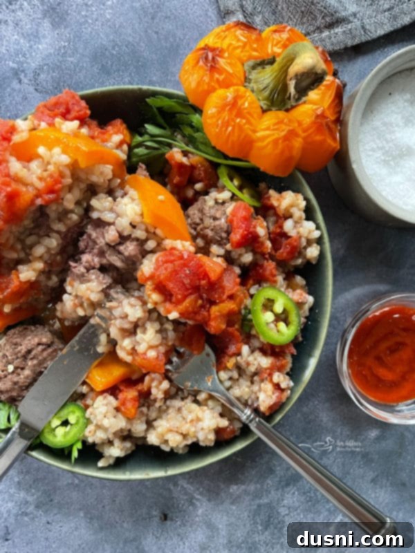 A perfectly cooked stuffed pepper half in a white bowl, showcasing the delicious filling.