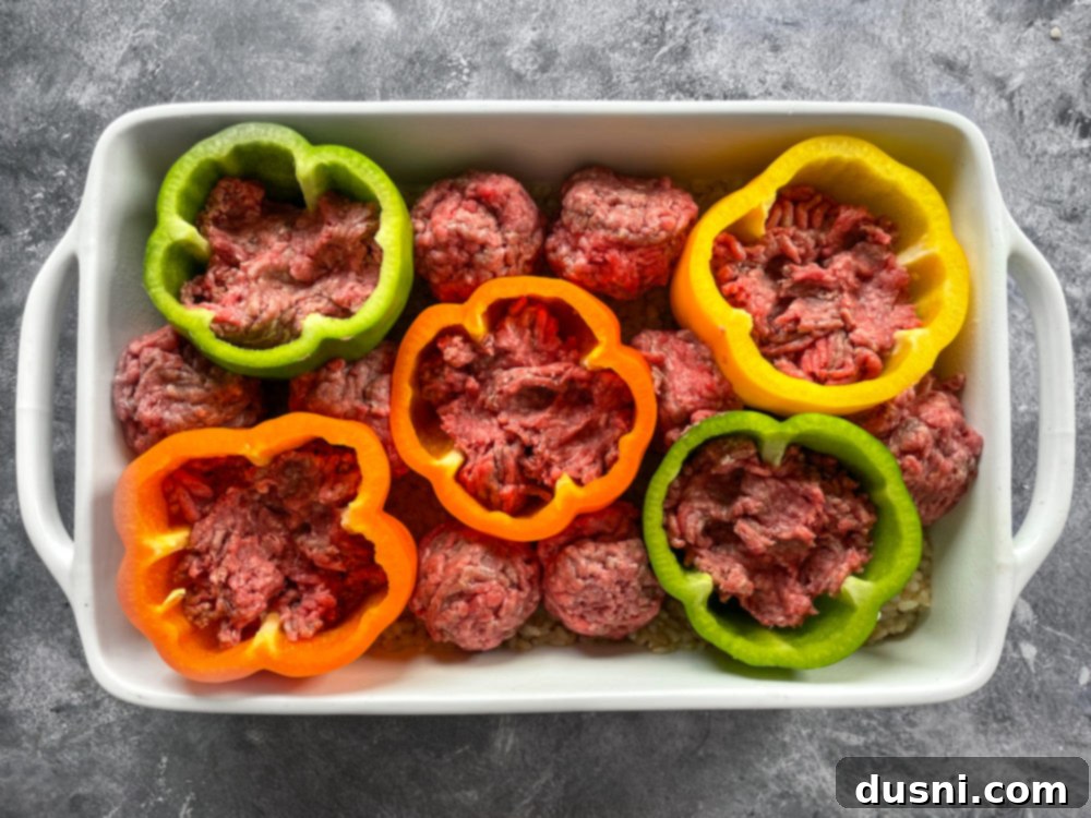Close-up of ground beef mixture stuffed into bell peppers in a baking dish.