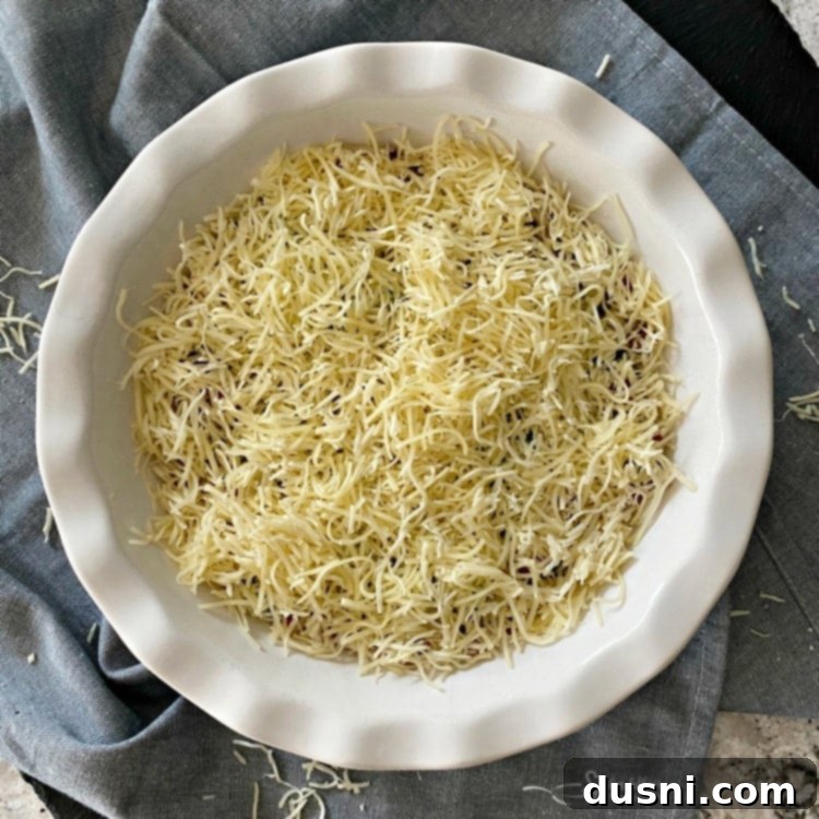 Prepping the pie plate with bacon, green onions, and Swiss cheese for Impossible Pie