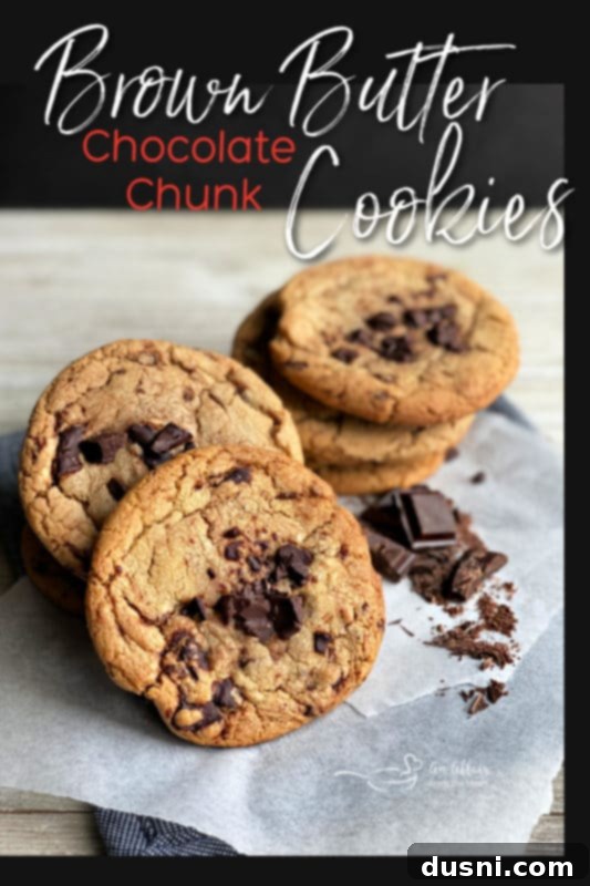 A deliciously tempting close-up of a single Brown Butter Chocolate Chunk Cookie with perfectly melted chocolate, ready to be bitten.
